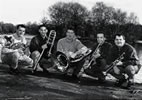 Black & white image of the quintet sitting outside with their instruments