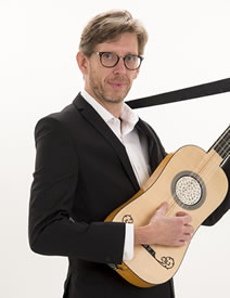 Matthew Nisbet standing with baroque guitar
