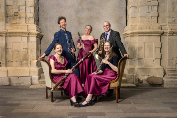 The Galliard Ensemble sitting & standing with their instruments